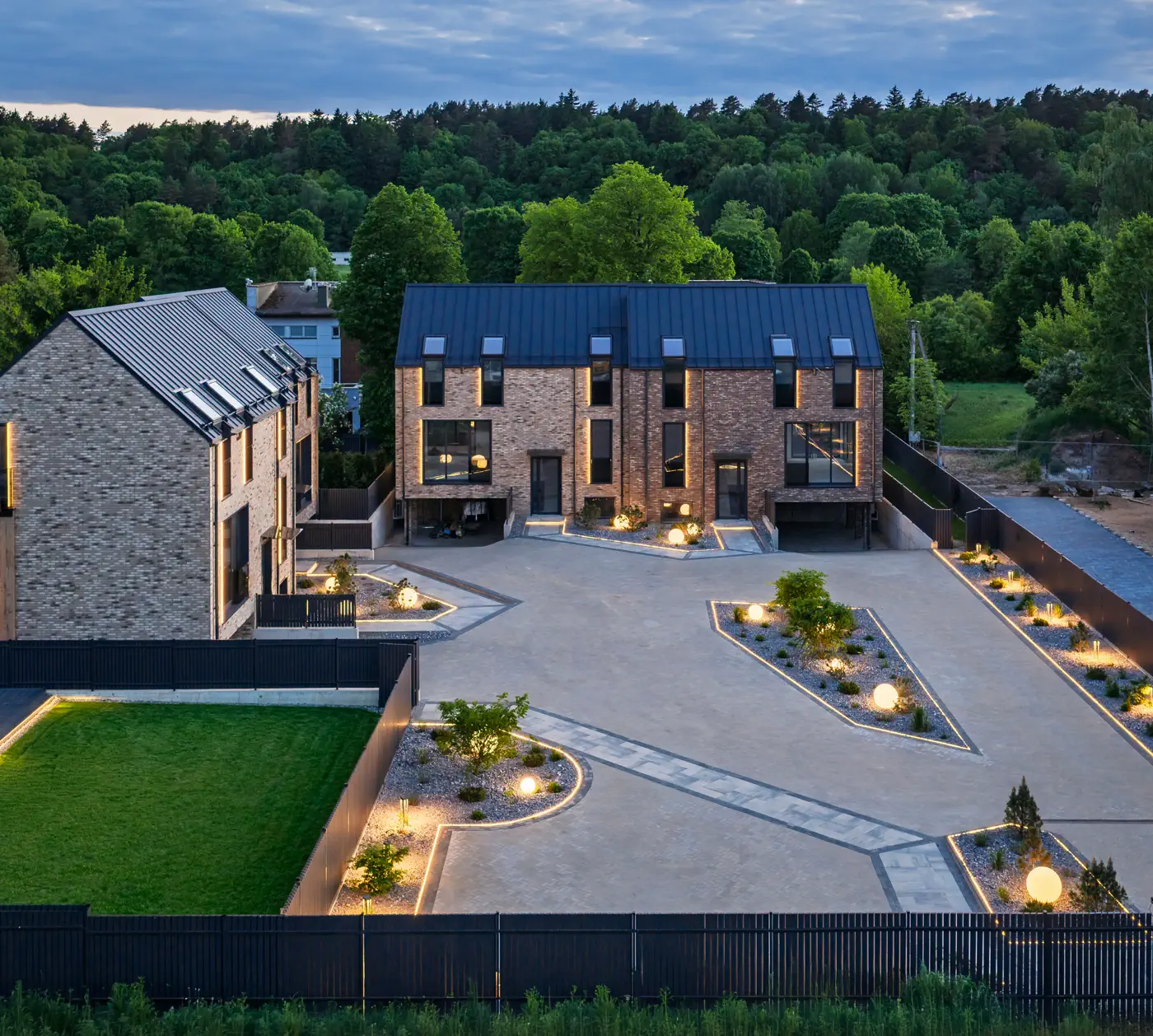 Vaidilutės 37 at dusk – clinker brick and timber facade